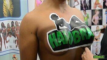 Madson pinta a Ana Julia con el logo de Hardbrazil en la feria erotika más grande de Brasil